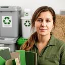 Nachhaltigkeitsbeauftragte vor Materialproben und Recyclingbehältern